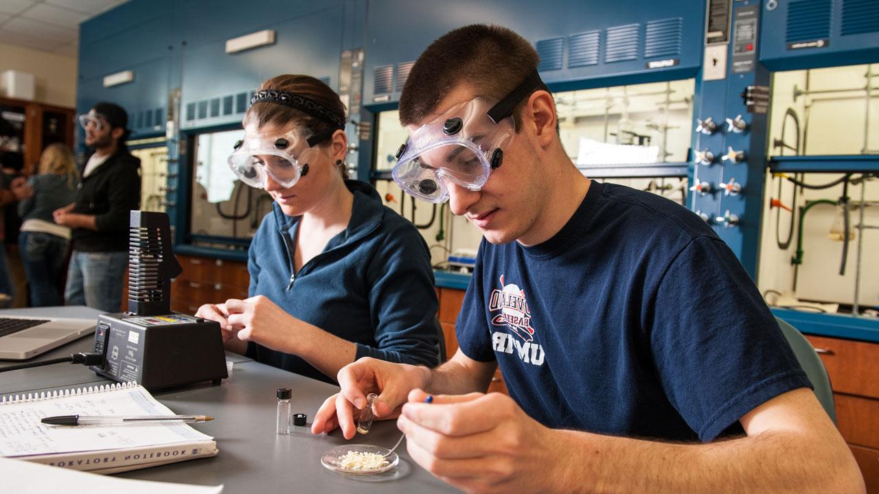Chemistry students in lab wearing protective goggles.